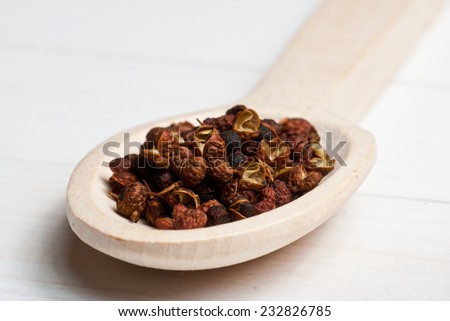 Spices. Sichuan pepper on wooden spoon - shallow depth of field