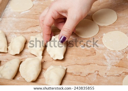 Woman making polish (called russian) dumplings with potatoes and cottage cheese