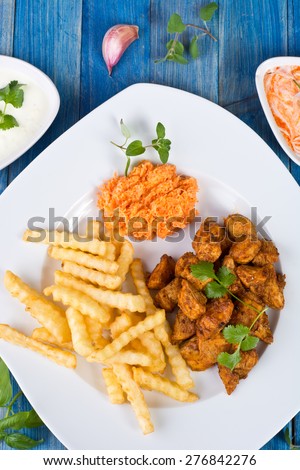 Fried chicken pieces with french fries and sauces