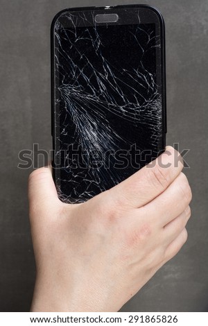 Smartphone with damaged screen in human hand