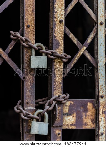 rusty chain and master key locked on grunge iron gate