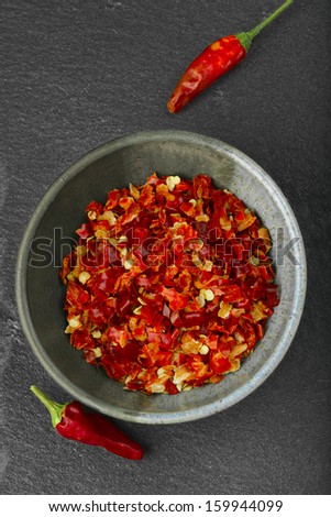 Bowl of crushed spicy pepper. Concept of spicy cuisine.