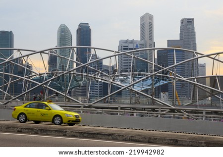 SINGAPORE - AUGUST 23, 2014: Taxi passes along pedestrian The Helix Bridge. Bridge won the \'World\'s Best Transport Building\' award at the World Architecture Festival in the 2011.