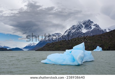 Global warming. Shatter of blue iceberg melts in front of The Gray Glacier, Patagonia, Chile