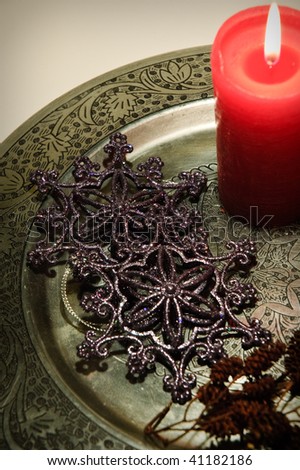 christmas decoration, red candle on a silver plate