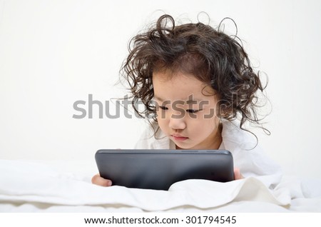 Little girls playing on a tablet computing device - laying on the floor