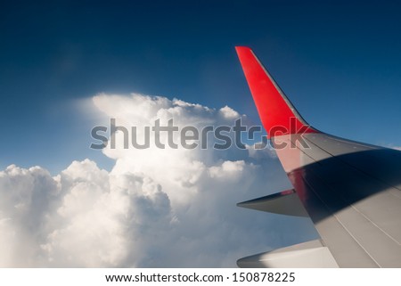 Wing aircraft against the blue sky and clouds. The view from the window.