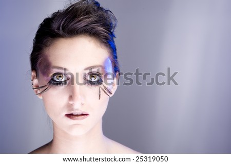 Attractive young lady with extravegant makeup and eyelashes with plain background