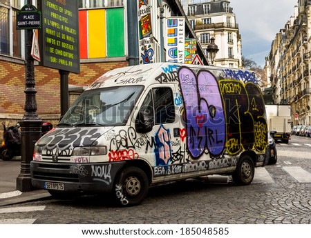 PARIS, FRANCE - 19TH MARCH 2014: A van covered in graffiti in down a street in Paris