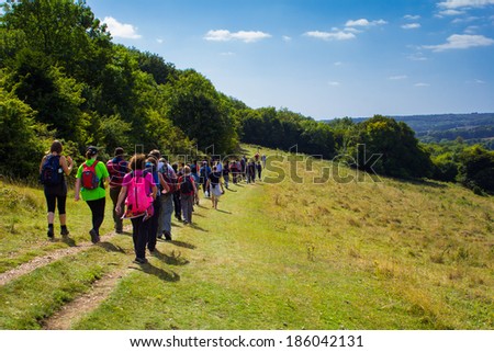 CHILTERN HILLS, UK - 31ST AUGUST 2013: A large group of people hiking the Chiltern Hills during a bright summer day