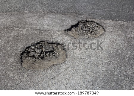 High view of pot holes in a road during the day