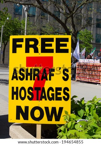 TORONTO, CANADA - 24TH MAY 2014: A sign at a demonstration in Toronto, protesting for the release of 7 hostages from camp Ashraf\'s in Iraq