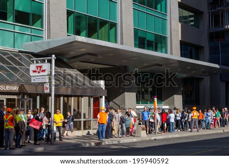 TORONTO, CANADA - MAY 31, 2014: Long queues of people outside Bloor Station in Toronto waiting for the shuttle bus\'s running whilst the subway is closed