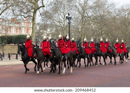 LONDON, UK - 8TH MARCH 2014: Horse Guards on horseback walking down The Mall towards Buckingham Palace during the day