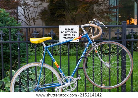 TORONTO, CANADA - 4TH SEPTEMBER 2014: Bike locked to a fence that says not to chain bikes to the fence