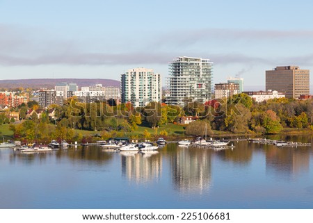 HULL, CANADA: 12 OCTOBER 2014: A view of boats docked along Ottawa River in the morning. Buildings can also be seen in the background