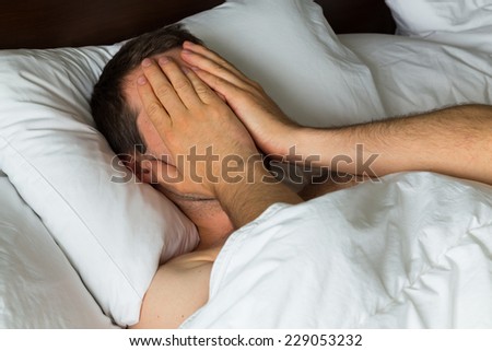 A man covering his eyes with his hand as he doesn\'t want to take up
