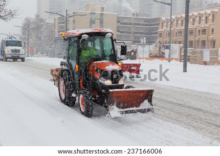 TORONTO, CANADA - 11TH DECEMBER 2014: A tractor on a road in Toronto during a snow storm