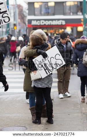TORONTO, CANADA - 24TH JANUARY 2015: Somebody holding a Free Hugs sign in Toronto and hugging somebody