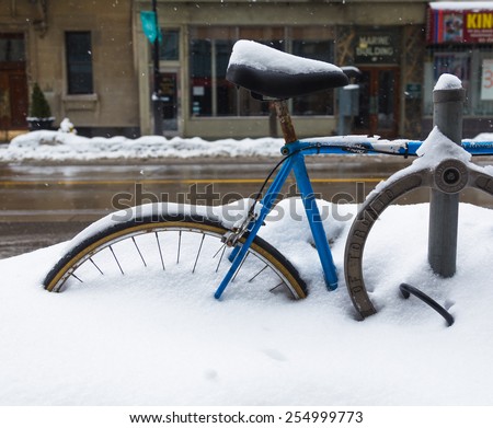 TORONTO, CANADA - 22ND FEBRUARY 2015: A bike and bike lock in Toronto during the winter, showing lots of snow