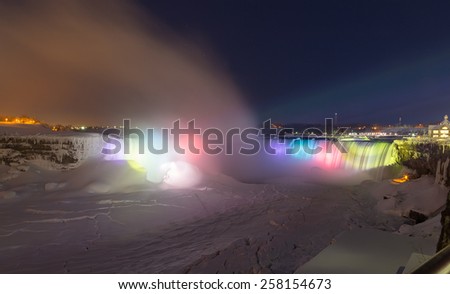 NIAGARA FALLS, CANADA - 25TH FEBRUARY 2015: The Horseshoe Falls at night in the winter, showing lightbeams on the Falls and snow and ice