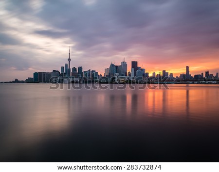 A view of the Toronto Skyline at sunset with reflections in the water. Taken with a long exposure.