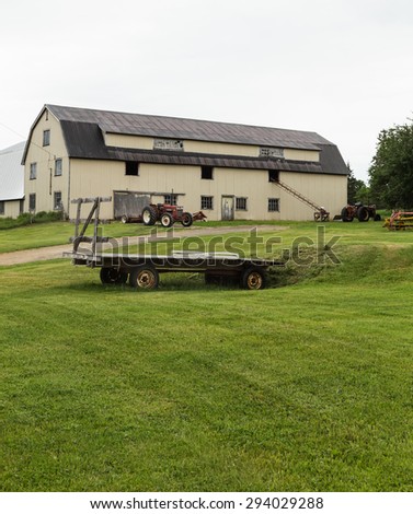 CAPE BRETON, CANADA - 5TH JULY 2015: The outside of a Barn with lots of Farm equipment outside during an overcast day in the summer