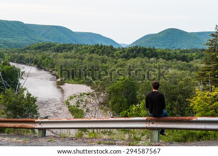 A man gazing out to the hills and mountains in Cape Breton