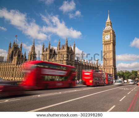 LONDON, UK - 21ST JULY 2015: Big Ben in Westminster with red double decker buses going past during the day.