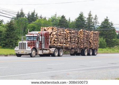 CAPE BRETON, CANADA - 8TH JULY 2015: A Timber Truck on a road in Cape Breton, Nova Scotia showing lots of tree trunks in the trailer.