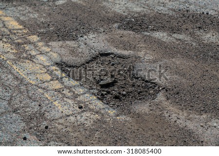 Closeup to a pothole on a road in Cape Breton Island.