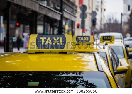 buDAPEST, HUNGARY - 29TH OCTOBER 2015: Signs for yellow Taxi\'s parked on a street in Budapest during the day.