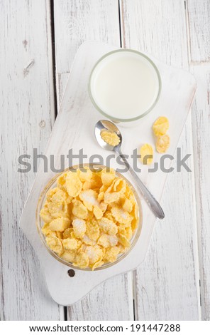 Corn flakes and milk in a jug.