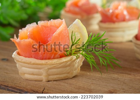 Tartlets with salmon, lemon and decorated with dill.
