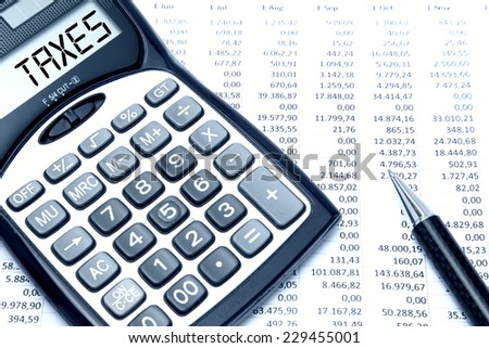 Calculator with TAXES text with calculation sheet background
