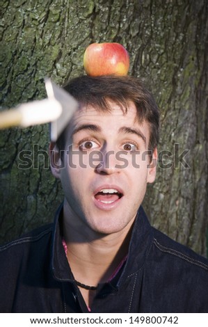 Head-and-shoulders recording one young man on the tree with apples on his head and the camera on him Court ducks arrow
