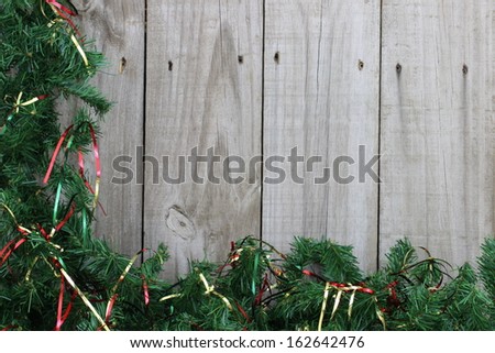Holiday border with garland and ribbon on wooden fence