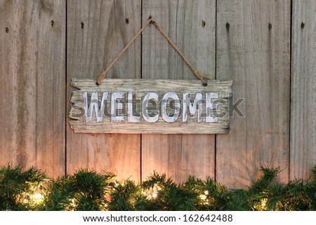 Country welcome sign with lighted garland border on wooden fence
