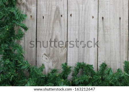Green garland border on wooden fence