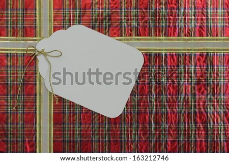 Plaid gift wrapped package with large blank gift tag