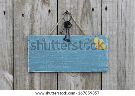 Antique blue sign hanging on wood door with iron keys