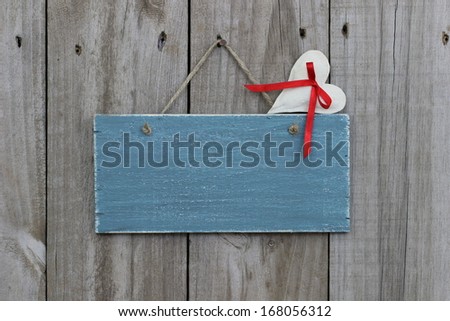 Antique blue sign hanging on wood door with muslin heart