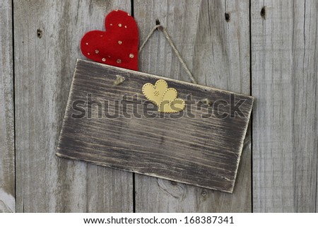 Blank wood sign hanging on door with red and gold hearts