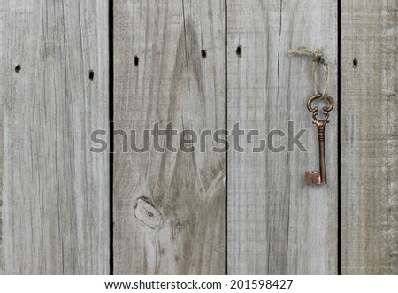 Brass skeleton key hanging from rope on rustic wooden door