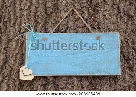 Vintage blank blue sign with hearts hanging on tree