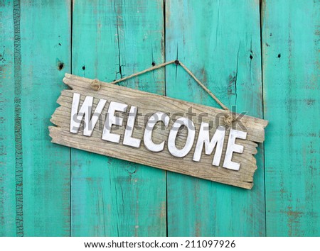 Rustic wood welcome sign hanging on weathered antique blue background