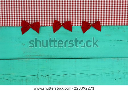 Blank antique green old wood sign with red checkered border and red velvet bows