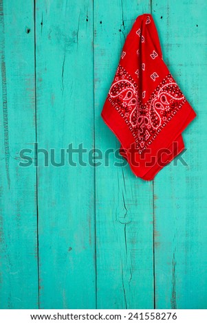 Red western bandanna or handkerchief hanging on blank antique teal blue old weathered background