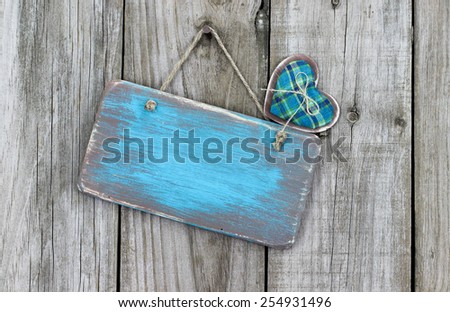 Blank ice teal blue wood sign with country heart hanging on rustic wooden background