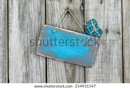Blank ice teal blue wood sign with fabric heart hanging on rustic wooden background